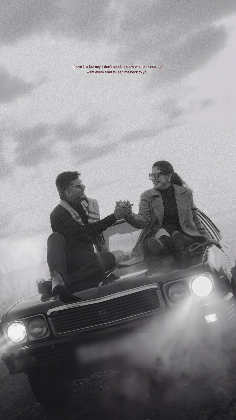 Bhoomika and Sanjay on a car bonnet under a cloudy sky, black and white
